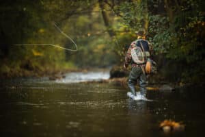 Angler walking down the river while enjoying the best Durango fly fishing