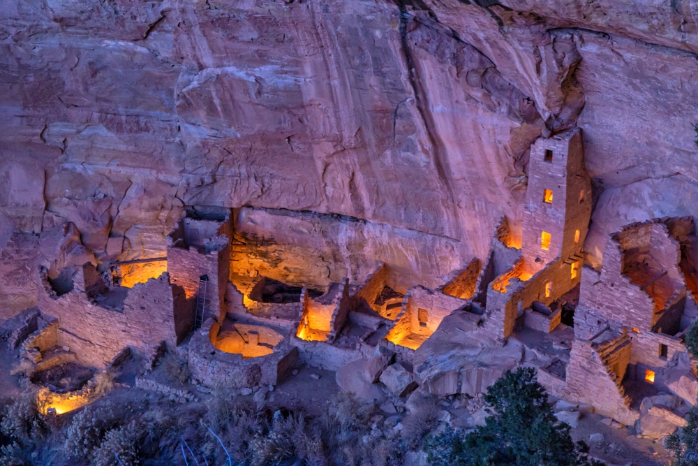 Cliff dwellings lit up in the evening at Mesa Verde National Park