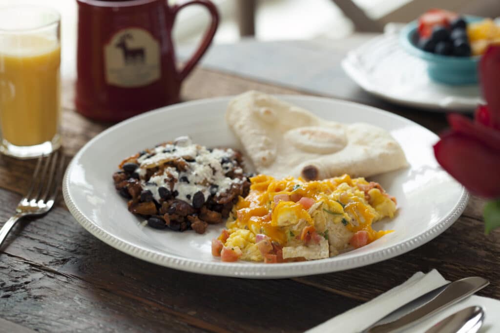 Table set with egg scramble, black beans and cheese, and tortilla. Our delicious breakfasts are just one reason we are the best Durango Lodging.
